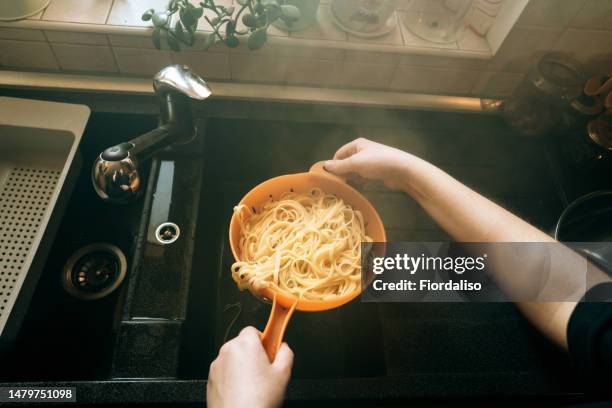 preparing food at home in the kitchen. cooking food - colander stockfoto's en -beelden