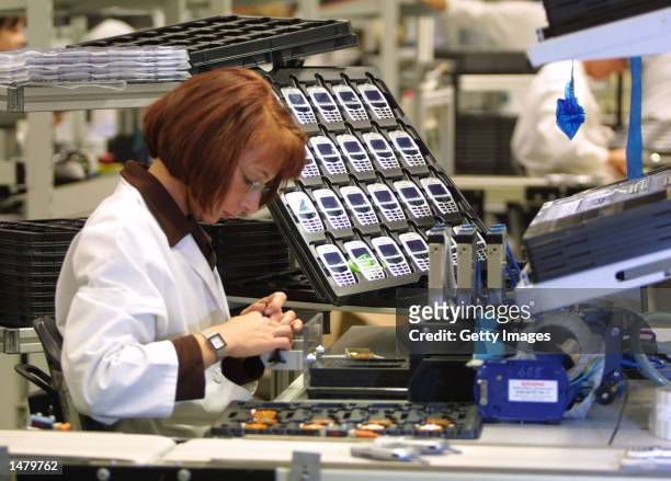 Worker assembles mobile phones at a Siemens factory in Kamp-Lintfort, Germany, in this 2001 file photo. Siemens is among Germany's biggest...