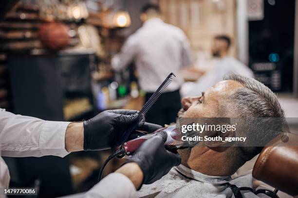 barber trimming man's beard - hair clipper stock pictures, royalty-free photos & images