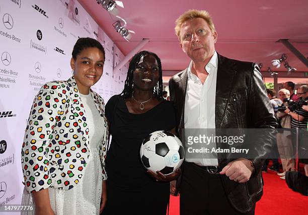 Auma Obama and daughter Akini meet Boris Becker ahead of the Minx By Eva Lux Show at Mercedes-Benz Fashion Week Spring/Summer 2013 on July 7, 2012 in...