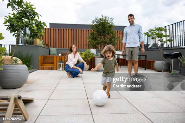 famille heureuse jouant au soccer dans leur cour arrière - family garden play area photos et images de collection