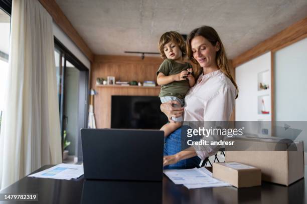mãe administrando seu negócio de comércio eletrônico em casa enquanto a levava de seu filho - ocupado - fotografias e filmes do acervo