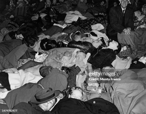 Roland Neave sucks his thumb as he sleeps alongside his brother, Peter Neave, as a number of people sleep while camping out ahead of the Coronation...