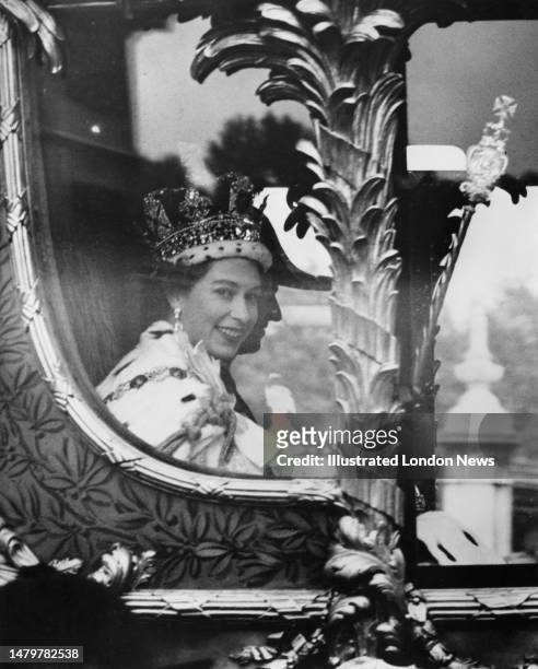 British Royal Elizabeth II, wearing the Imperial State Crown, and her husband, Prince Philip, Duke of Edinburgh, seen through the window of the Gold...