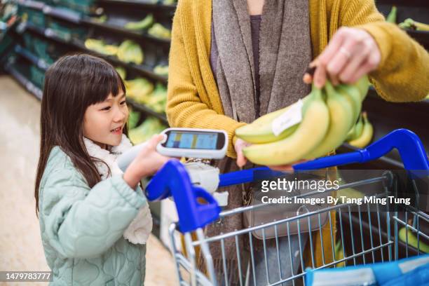 daughter & mom doing groceries shopping in supermarket with using handheld barcode scanner. the concept of modern technology. - infrared lamp 個照片及圖片檔