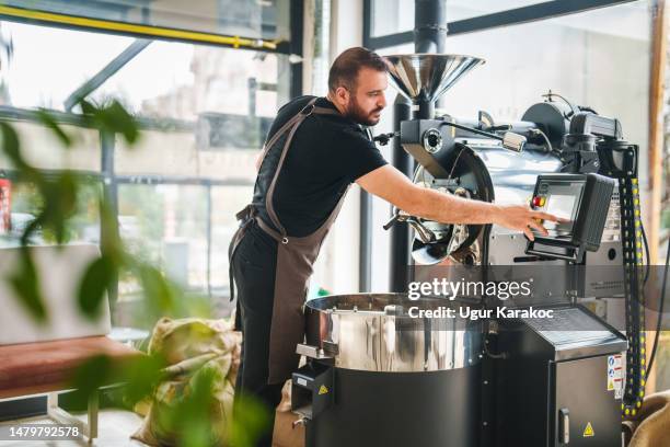 man using touch screen of roasting coffee machine control panel - coffee roasting process stock pictures, royalty-free photos & images