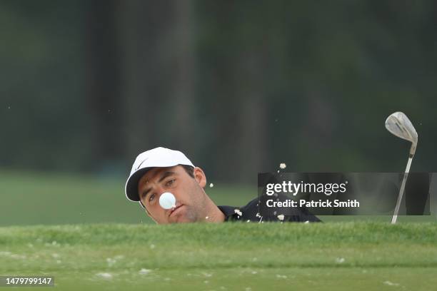 Scottie Scheffler of the United States plays a shot from a bunker on the 17th hole during a practice round prior to the 2023 Masters Tournament at...