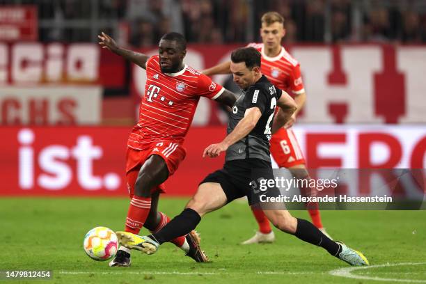 Dayot Upamecano of FC Bayern Munich battles for possession with Nicolas Hoefler of Sport-Club Freiburg during the DFB Cup quarterfinal match between...
