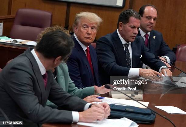 Former U.S. President Donald Trump sits with his attorneys inside the courtroom during his arraignment at the Manhattan Criminal Court April 4, 2023...