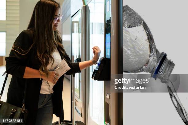 geschäftsfrau, die wasser in einem automaten kauft. - gepäckautomaten stock-fotos und bilder