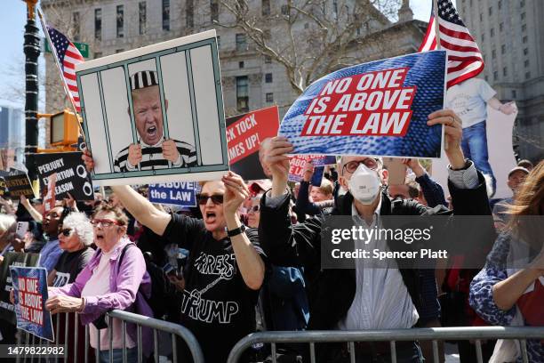 Opponents of former President Donald Trump gather outside of the Manhattan Criminal Court during his arraignment on April 04, 2023 in New York City....