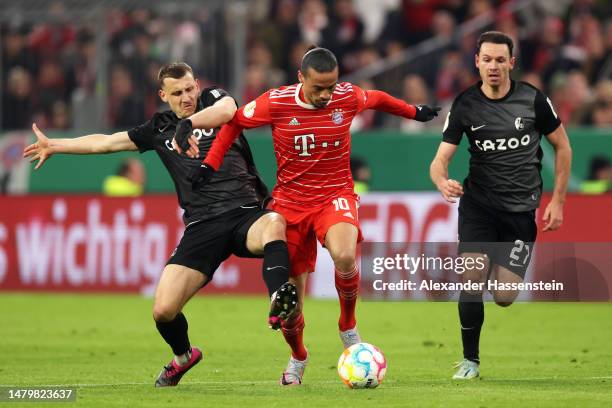 Leroy Sane of FC Bayern Munich battles for possession with Maximilian Eggestein of Sport-Club Freiburg during the DFB Cup quarterfinal match between...