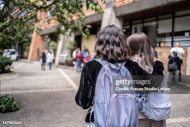 rear view of student friends arriving at university - arm around friend back stock pictures, royalty-free photos & images