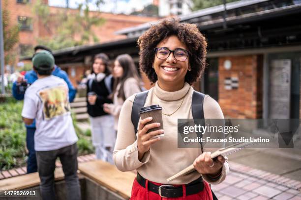 retrato de un joven estudiante universitario sosteniendo una taza de café al aire libre - estudiantes universitarios bogota fotografías e imágenes de stock