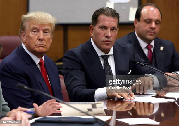 Former U.S. President Donald Trump sits with his attorneys Joe Tacopina and Boris Epshteyn inside the courtroom during his arraignment at the...