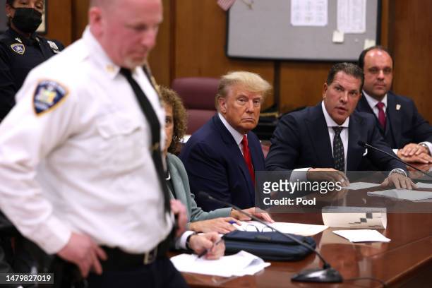 Former U.S. President Donald Trump sits with his attorneys Joe Tacopina and Boris Epshteyn inside the courtroom during his arraignment at the...