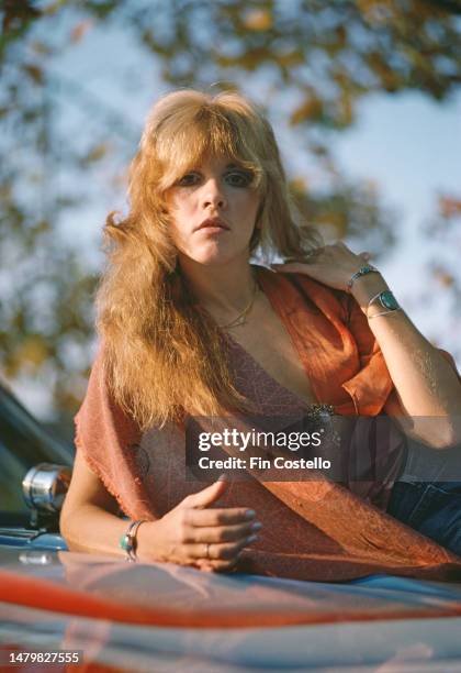 American singer and songwriter Stevie Nicks of rock band Fleetwood Mac, in New Haven, Connecticut, October 1975. Nicks is posed on a Chevelle car...