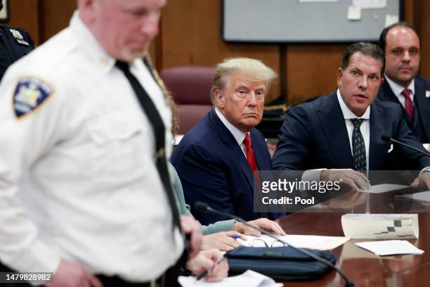 Former U.S. President Donald Trump sits in the courtroom with his attorneys Joe Tacopina and Boris Epshteyn during his arraignment at the Manhattan...