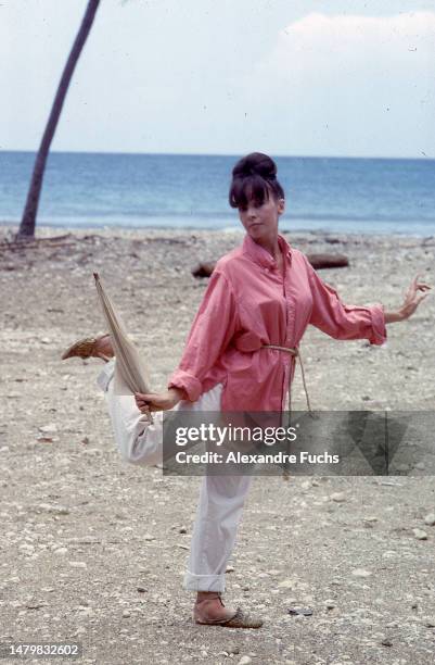 Actress Leslie Caron dances with an umbrella while at Jamaica in 1963.