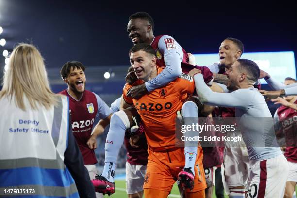 Bertrand Traore of Aston Villa celebrates on the back of teammate Emiliano Martinez of Aston Villa after the team's victory in the Premier League...