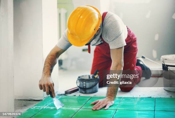 handyman installing ceramic tiles. - flooring installation stock pictures, royalty-free photos & images