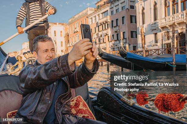 man taking pictures with his phone while on gondola - tourist selfie stock pictures, royalty-free photos & images