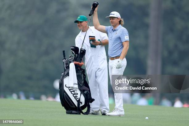 Cam Smith of Australia plays his second shot on the 15th hole watched by his caddie Ian Pinfold during practice prior to the 2023 Masters Tournament...