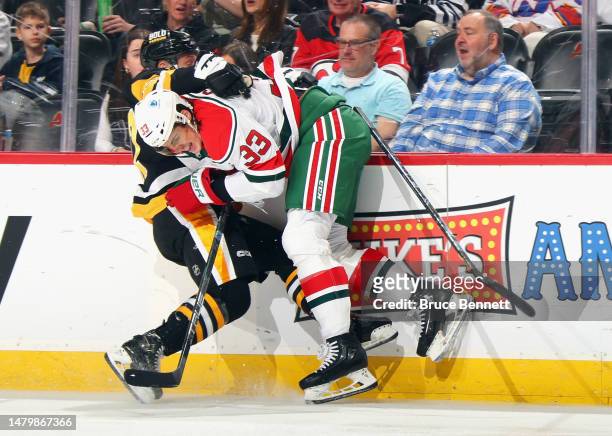 Ryan Graves of the New Jersey Devils stops Bryan Rust of the Pittsburgh Penguins during the first period at the Prudential Center on April 04, 2023...