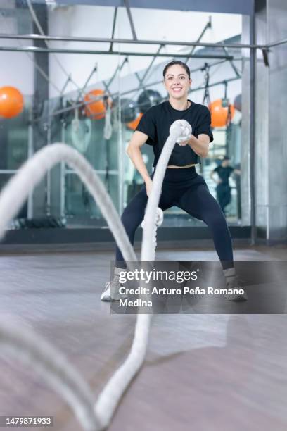 woman doing battle rope training - cross training shoes stock pictures, royalty-free photos & images