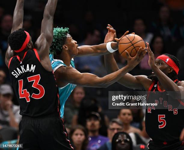 Kai Jones of the Charlotte Hornets drives between Pascal Siakam and Precious Achiuwa of the Toronto Raptors during the first half of the game at...