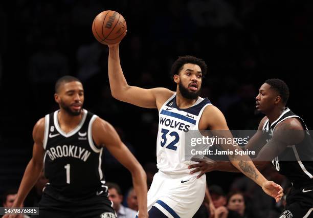 Karl-Anthony Towns of the Minnesota Timberwolves controls the ball as Mikal Bridges and Dorian Finney-Smith of the Brooklyn Nets defend during the...