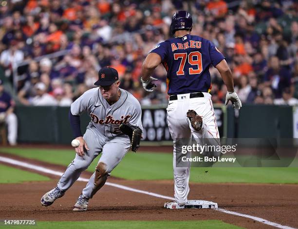 Jose Abreu of the Houston Astros reaches first base as Spencer Torkelson of the Detroit Tigers comes off the base in the first inning at Minute Maid...