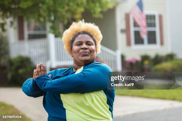 mujer afroamericana haciendo ejercicio, estiramiento - black pants woman fotografías e imágenes de stock