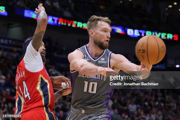 Domantas Sabonis of the Sacramento Kings passes as Brandon Ingram of the New Orleans Pelicans defends during the first half at the Smoothie King...