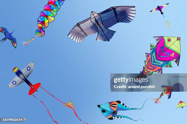 kites flying in clear blue sky - drachen stock-fotos und bilder
