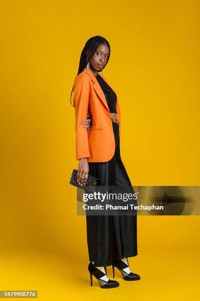 fashionable woman wearing smart casual outfit - bolso naranja fotografías e imágenes de stock