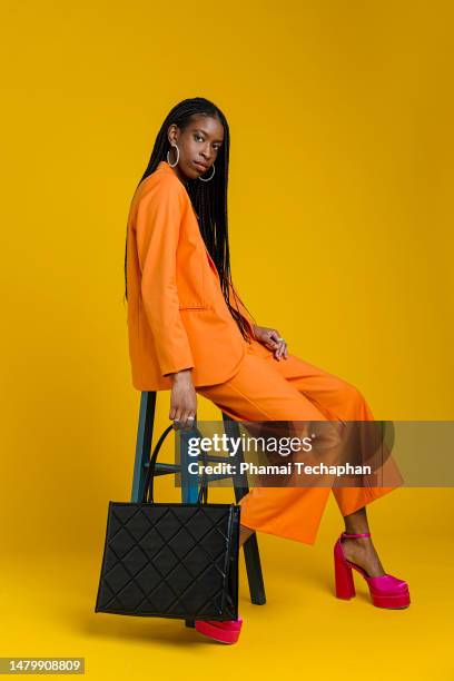 fashionable woman wearing smart casual outfit - bolso naranja fotografías e imágenes de stock