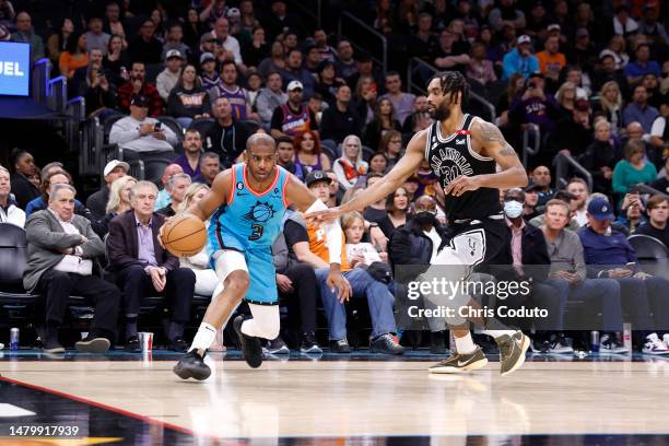 Chris Paul of the Phoenix Suns drives past Keita Bates-Diop of the San Antonio Spurs during the second half at Footprint Center on April 04, 2023 in...