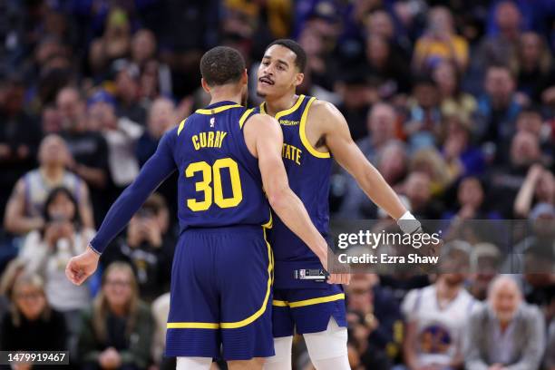 Jordan Poole and Stephen Curry of the Golden State Warriors bump chests during their game against the Oklahoma City Thunder in the second half at...