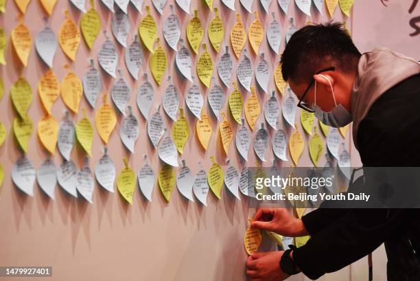 Citizen puts a sticky note with message on a wall to mourn for martyrs at the Memorial Museum of the Chinese People's Anti-Japanese War before...