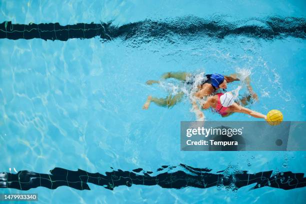 fuerte enfrentamiento defensivo en el partido de waterpolo femenino profesional - waterpolo fotografías e imágenes de stock