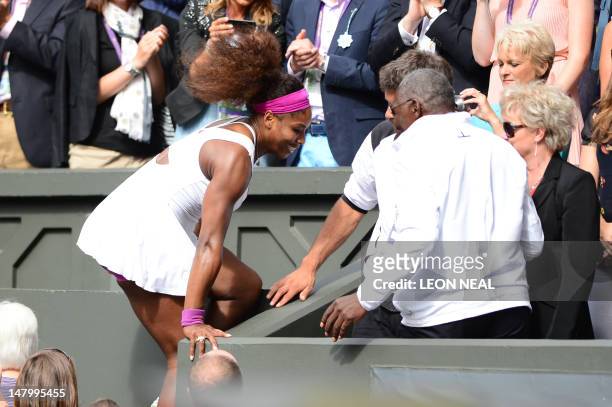 Player Serena Williams climbs into the Royal Box to celebrate with her father Richard after her women's singles final victory over Poland's Agnieszka...