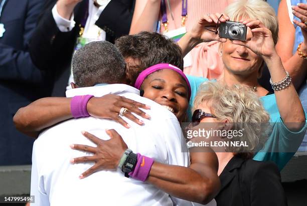 Player Serena Williams climbs into the Royal Box to celebrate with her father Richard after her women's singles final victory over Poland's Agnieszka...