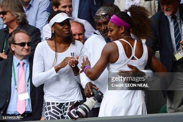 Player Serena Williams climbs up into the Royal Box to embrace her father Richard and sister Venus Williams after her women's singles final victory...