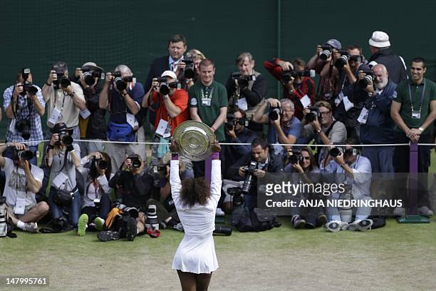 Player Serena Williams poses for photographs with the trophy, the Venus Rosewater Dish after her women's singles final victory over Poland's...