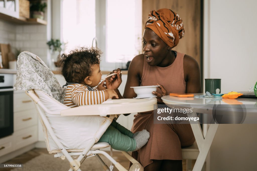 Mom feeding her baby boy at home