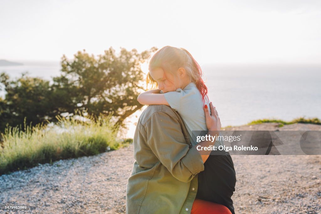 Heartwarming and touching hug of mother and daughter in mountains. Mother and daughter's mountain exploration.