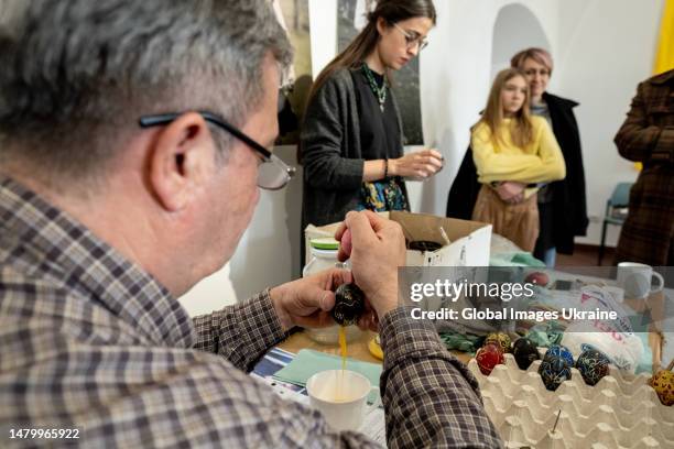 Oleh Pankiv blows out ready pysankas to make them hollow on April 1, 2023 in Lviv, Ukraine. Pysanky is the art of writing with wax on eggs to make...