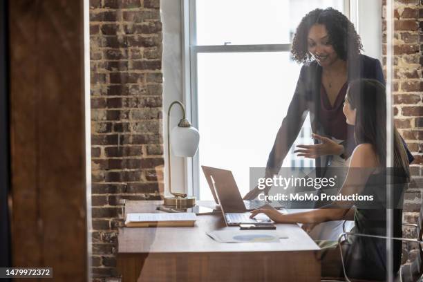 female colleagues collaborating in modern office - brightly lit office stock pictures, royalty-free photos & images