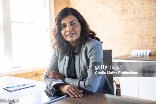 portrait of businesswoman in modern conference room - 50 year old indian lady stock pictures, royalty-free photos & images